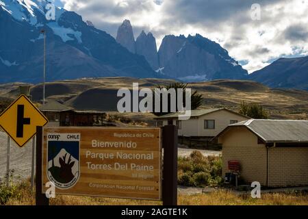 Der Paine Towers und Hörner dominieren die angezeigt wird, wenn Sie das Schild "Willkommen Torres del Paine Nationalpark - National Forest Corporation'. Stockfoto