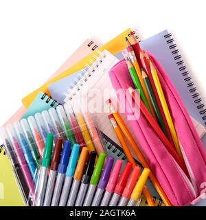 Verschiedene Schulmaterial wie Notebooks und rosa Federmäppchen gegen einen weißen Hintergrund isoliert Stockfoto