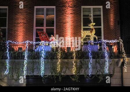 Central London, London, 21. Dezember 2019. Ein Weihnachtsmann mit Schlitten und Rentier auf Berkeley Square. Geschäfte, Hotels, Restaurants und Wohnhäuser haben alle Hallen herausgeputzt und ihre Eingänge in festlichem Glanz um Mayfair, der Oxford Street und der Regent Street in London in den letzten Tagen vor Weihnachten dekoriert. Stockfoto