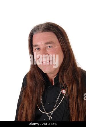 Ein mittleres Alter indigener in einem Porträt Bild trägt ein schwarzes Hemd und Schmuck mit seinen langen Haaren, auf weißem Hintergrund Stockfoto
