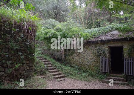 Ein altes Steinhaus ist nicht mehr in Gebrauch und überwachsen mit Pflanzen im Yangmingshan National Park (陽明山國家公園) in Taiwan Stockfoto