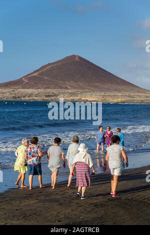 EL Medano, Spanien - 9. JULI 2019: älterer Frauen zu Fuß auf Playa El Medano Strand während sunrisee am 9. Juli 2019 in El Medano, Spanien. Stockfoto