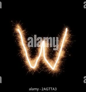 Kleinschreibung w Buchstabe des Alphabets von squib geschrieben Funken auf schwarzem Hintergrund. Stockfoto