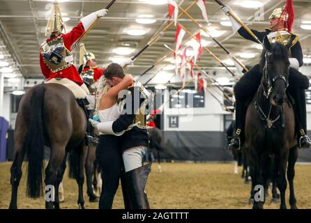 Household Cavalry Trooper Jonathan Adams schlägt seine Freundin Megan Baldry bei Tag sechs der London International Horse Show in London Olympia. Stockfoto