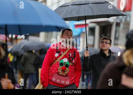 Ein Mann mit einem Regenschirm während ein heftiger Platzregen auf dem Londoner Oxford Street am letzten Samstag vor Weihnachten. Stockfoto