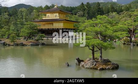 KYOTO, JAPAN - April, 15, 2018: kinkakuji und zwei kleine Bäume auf einem Teich Stockfoto