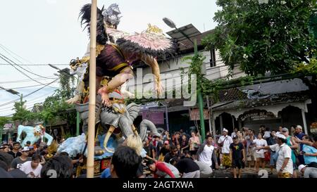 KUTA, Indonesien - März 16, 2018: Seitenansicht des hinduistischen Männer Bewegen eines ogoh-ogoh Statue auf einer Straße Stockfoto