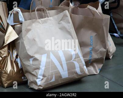 Viele Einkaufstaschen sind auf dem Boden außerhalb des Primark Store gesehen, wie Käufer Regen und Kälte, last minute präsentiert am letzten Samstag vor Weihnachten erhalten Sie tapfer. Stockfoto