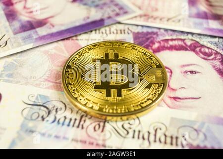 Cryptocurrency gold Bitcoin Münze auf ein Britisches Pfund Sterling Rechnungen. - Hautnah, makroaufnahme - pan Bewegung Stockfoto