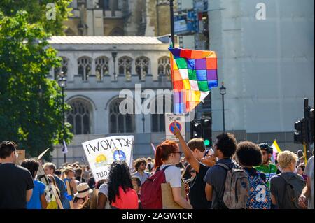 LONDON - September 20, 2019: Aussterben Rebellion Demonstrant hält ein Gay Pride Flagge hoch in Parliament Square an einem Klimawandel März Stockfoto