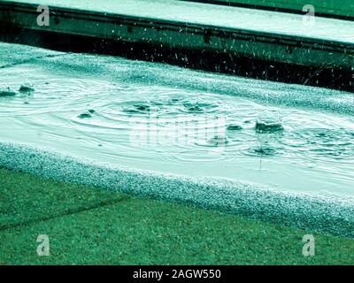 Die Regentropfen fallen auf den Boden bei starken Regenfällen. Stockfoto