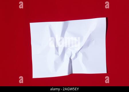 Gefaltetes Blatt Papier auf einem roten Hintergrund Stockfoto