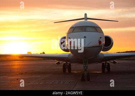 Ein Passagier/Private Jet gegen einen Sonnenaufgang/Sonnenuntergang. Stockfoto
