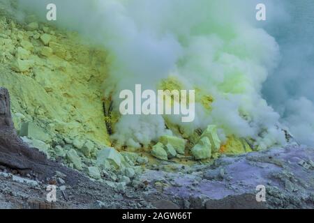 Gas Probleme aus vulkanischen Schlot in Mount Ijen Krater, Indonesien, Ost Java, Indonesien. Gelber Schwefel deckt Krater Wand im Hintergrund. Stockfoto