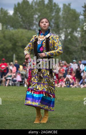 Eine einheimische Frau, die im Powwow des Canada Day auf Prince's Island einen Klingeltanz aufführt Stockfoto