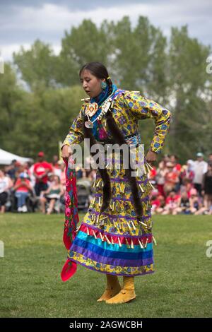 Indigene Frau, die während des Canada Day Powwow im Prince's Island Park Jingle-Tanz aufführt Stockfoto