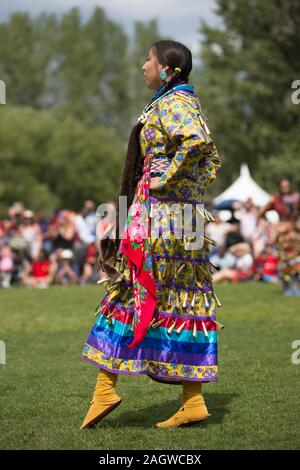 Indigene Frau, die während des Canada Day Powwow in Calgary Jingle-Tanz aufführt Stockfoto