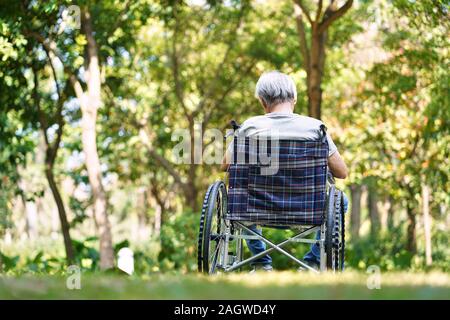 Ansicht der Rückseite des asiatischen alte Mann sitzt draußen im Rollstuhl, Kopf nach unten Stockfoto