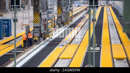 Lehrte, Deutschland. 16 Dez, 2019. Bauarbeiter stehen am Güterbahnhof Megahub Lehrte in der Region Hannover. Östlich von Hannover, in der Nähe der Autobahn A2, eine neue Art von Freight Station für den Umschlag von Containern zwischen Zügen und Lkws sowie zwischen den Zügen gebaut wird. Nach Angaben der Bahn, es ist die erste Station dieser Art in Deutschland. Credit: Julian Stratenschulte/dpa/Alamy leben Nachrichten Stockfoto