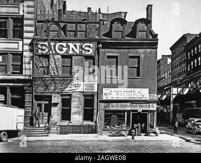 1930er Jahre in New York City - Melden sie Unternehmen mit dekorative Schmiedearbeiten entlang Dach, Auto kühler Shop, besteht aus 3-stöckigen Gebäuden, die erhöhte Eisenbahn nur auf der rechten Seite sichtbar. Broome Street, Nr. 504-506, Manhattanca. 1935 Stockfoto