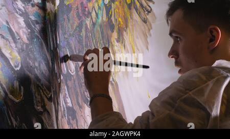 Künstler Designer zieht ein Adler an der Wand. Handwerker Dekorateur malt mit Acryl öl Farbe. Maler Maler gekleidet in Lack auftragen. Indoor. Stockfoto