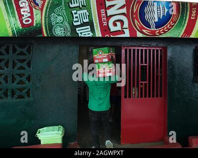 Monrovia. 19 Dez, 2019. Foto am Dez. 19, 2019 zeigt die lokale Bevölkerung die Packs von Tsingtao Bier zu einem lokalen Geschäft vor Tsingtao Beer Festival in Monrovia, Liberia. Die Tsingtao Beer Festival in Liberia begann am Samstag mit der 5-km Mini-Marathon und in der Hauptstadt Monrovia ein freundliches Fußballspiel statt. Das Festival wird in 15 Ländern, die zwischen Dezember 2019 und Oktober 2020 statt. Quelle: Ma Xing/Xinhua/Alamy leben Nachrichten Stockfoto