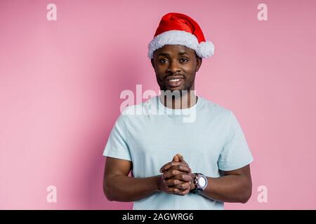 Stattliche schwere Bärtigen afrikanischen amerikanischen Jungen Mann tragen rote Weihnachtsmütze, weisses T-Shirt, an Kamera suchen Mit ruhig, selbstsicher ausdrücken, isoliert Stockfoto