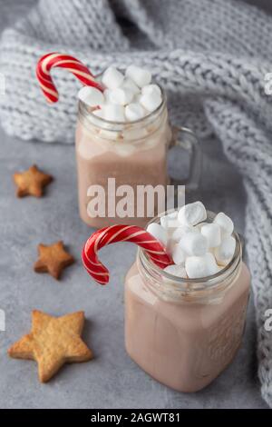 Zwei Becher mit heißer Schokolade und Marshmallows mit Ingwer Cookies auf grauem Hintergrund. Vertikale Ausrichtung Stockfoto