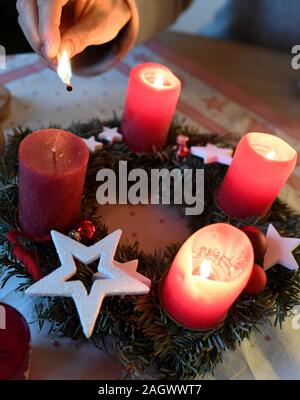 Garmisch Partenkirchen, Deutschland. 22 Dez, 2019. Abbildung - eine Frau, die Lichter der vierten Kerze am Adventkranz am vierten Advent. Quelle: Angelika Warmuth/dpa/Alamy leben Nachrichten Stockfoto