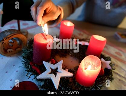 Garmisch Partenkirchen, Deutschland. 22 Dez, 2019. Abbildung - eine Frau, die Lichter der vierten Kerze am Adventkranz am vierten Advent. Quelle: Angelika Warmuth/dpa/Alamy leben Nachrichten Stockfoto