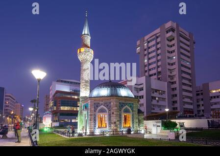 Izmir, Türkei. Konak Moschee (Konak Cami) auf dem zentralen Platz, neben dem Uhrenturm in der Nacht. Stockfoto