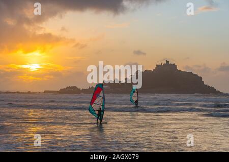 Marazion, Cornwall, UK. 22. Dezember 2019. Windsurfer wurden für den Winter solstice Sonnenaufgang heute Morgen im Meer in Marazion, mit St Michaels Berg im Hintergrund. Kredit Simon Maycock/Alamy Leben Nachrichten. Stockfoto