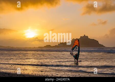 Marazion, Cornwall, UK. 22. Dezember 2019. Windsurfer wurden für den Winter solstice Sonnenaufgang heute Morgen im Meer in Marazion, mit St Michaels Berg im Hintergrund. Kredit Simon Maycock/Alamy Leben Nachrichten. Stockfoto