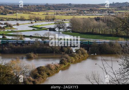 Lewes Großbritannien 22. Dezember 2019 - ein Zug fährt über gefluteten Feldern nördlich von Lewes in East Sussex Nach dem nächtlichen Regen mehr Wetter- und Hochwasserwarnungen über Großbritannien nach Tagen der ständige Regen erteilt wurden: Credit Simon Dack/Alamy leben Nachrichten Stockfoto