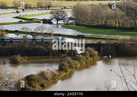 Lewes Großbritannien 22. Dezember 2019 - ein Zug fährt über gefluteten Feldern nördlich von Lewes in East Sussex Nach dem nächtlichen Regen mehr Wetter- und Hochwasserwarnungen über Großbritannien nach Tagen der ständige Regen erteilt wurden: Credit Simon Dack/Alamy leben Nachrichten Stockfoto