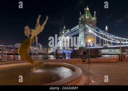 Europa, Großbritannien, London. Die Tower Bridge und das Mädchen mit dem Dolphin Fountain. Nacht Stadtbild Stockfoto
