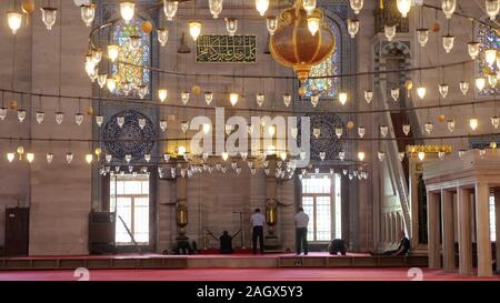 ISTANBUL, Türkei - 30. JULI 2019: Muslimische Männer beten in der Nähe der Wall in der wunderschönen Moschee mit traditionellen Laternen in Istanbul City Rückseite Ansicht am 30. Juli in Istanbul eingerichtet Stockfoto