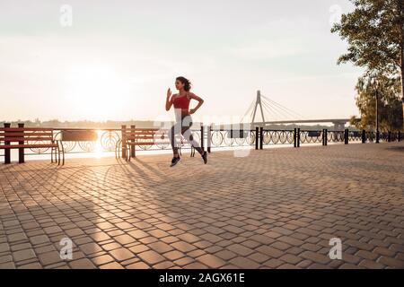 Aktiver Lebensstil. Frau Übung im Freien schnell im Park locker springen Stockfoto