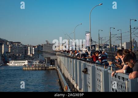 ISTANBUL, Türkei - 30. JULI 2019: Fischer auf der Galata Brücke voll mit Restaurants auf dem unteren Deck Stockfoto