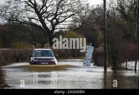 Lewes Großbritannien 22. Dezember 2019 - ein Auto verhandelt eine überflutete Straße in der Ortschaft Barcombe Mühlen in der Nähe von Lewes als mehr Wetter- und Hochwasserwarnungen haben über Großbritannien nach Tagen des Regens ausgestellt: Credit Simon Dack/Alamy leben Nachrichten Stockfoto