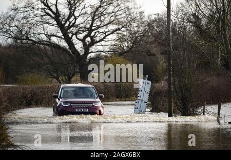 Lewes Großbritannien 22. Dezember 2019 - ein Auto verhandelt eine überflutete Straße in der Ortschaft Barcombe Mühlen in der Nähe von Lewes als mehr Wetter- und Hochwasserwarnungen haben über Großbritannien nach Tagen des Regens ausgestellt: Credit Simon Dack/Alamy leben Nachrichten Stockfoto