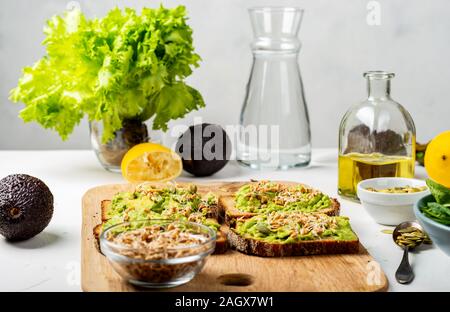 Sandwiches mit Avocado Guacamole auf ein Holzbrett auf den Tisch. Gesundes Essen in der Küche. Stockfoto