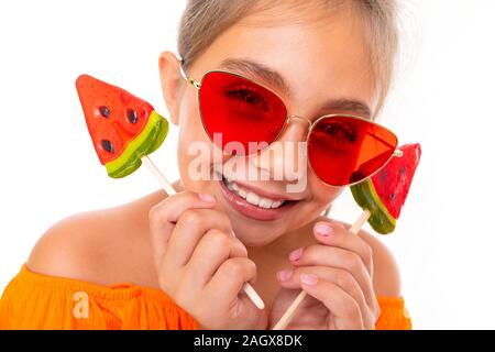 Porträt einer Gegerbten touristisch attraktiven Mädchen mit einem chupa Lutscher in Form einer Wassermelone auf weißem Hintergrund Stockfoto