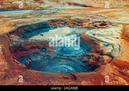 Mudpots in der geothermischen Bereich Hverir, Island. Den Bereich um den brodelnden Schlamm ist bunt und rissig. Stockfoto