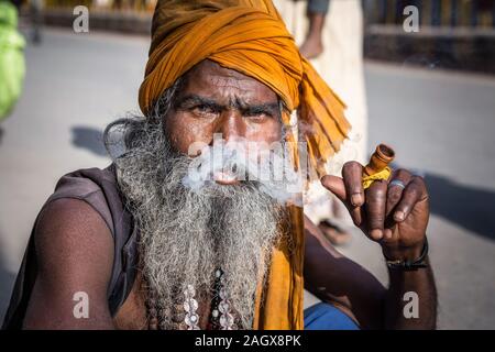 VARANASI, INDIEN - 18. MÄRZ 2017: heiliger Mann holding Holding und Rauchen Rohr in Varanasi, Indien. Stockfoto