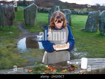 Drombeg, Glandore, Cork, Irland. 22. Dezember, 2019. Siobhán Housden von Clonakilty suchen Bei einer Sonnenuhr am Altar aus Stein während der Wintersonnenwende bei Drombeg Steinkreis außerhalb Glandore, County Cork, Irland. - Gutschrift; David Creedon/Alamy leben Nachrichten Stockfoto