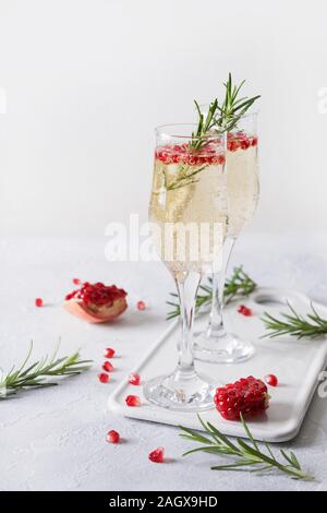 Zwei Glas Granatapfel Weihnachten Cocktail mit Rosmarin Zweig, Sekt, club Soda auf weißer Tisch. Xmas trinken. Close Up. Stockfoto