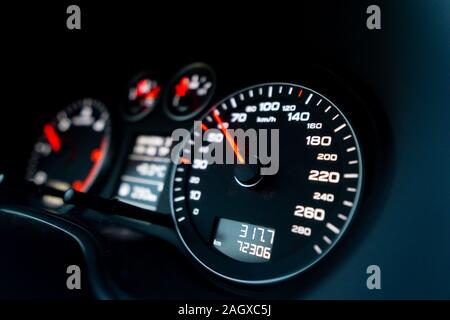 Nahaufnahme von einem Tachometer im Auto. Armaturenbrett mit Details mit Anzeigelampen und Instrumententafel. Moderne Einrichtung Stockfoto