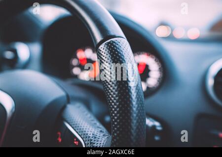 Nahaufnahme von einem Lenkrad und Tacho in einem Auto. Das Armaturenbrett. Dashboard details mit Anzeigelampen. Auto Instrumententafel. Armaturenbrett Stockfoto