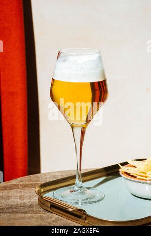 Bier in Flöte, Pils oder Pilsner, mit Tortilla-Chips, heller bunter Hintergrund Stockfoto